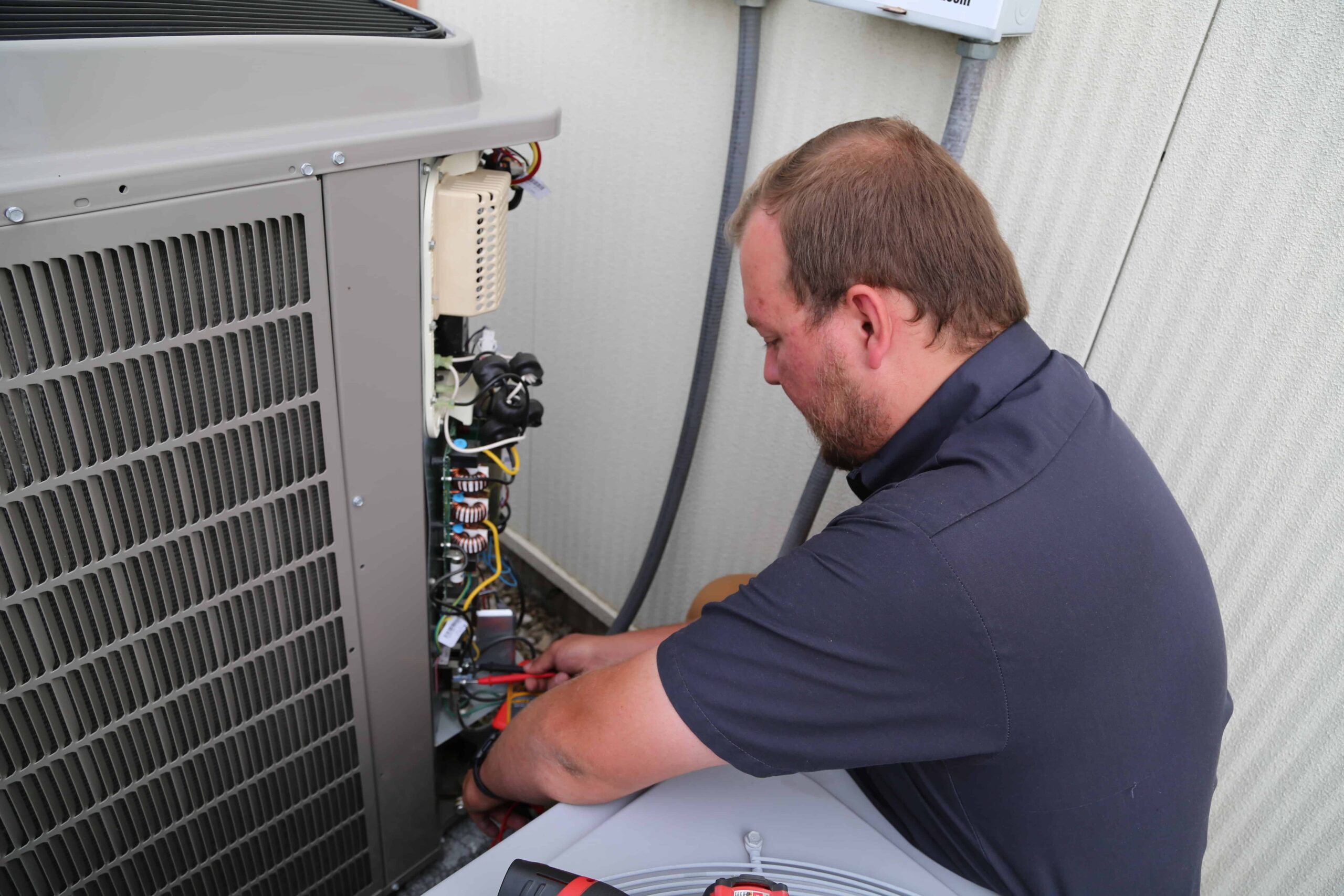 AC Tech performing routine maintenance on a Air Conditioner.